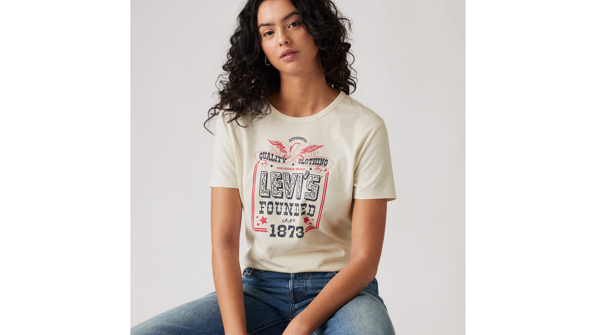 Woman in Levi's cream graphic tee and blue jeans