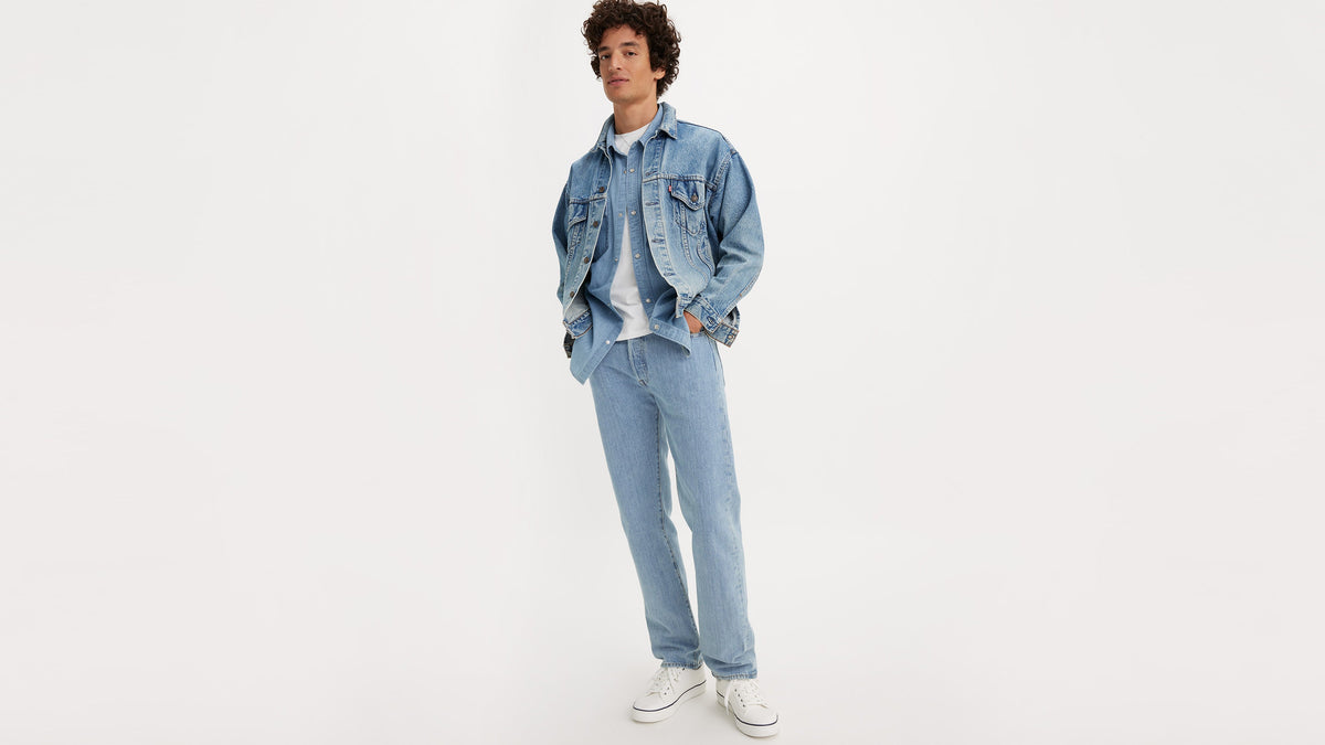 Full-body shot of man in layered white tee, denim jacket & Levi’s 501 jeans, front view