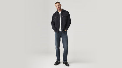 Front view of a man wearing dark wash Levi’s 514 jeans with a black overshirt & loafers