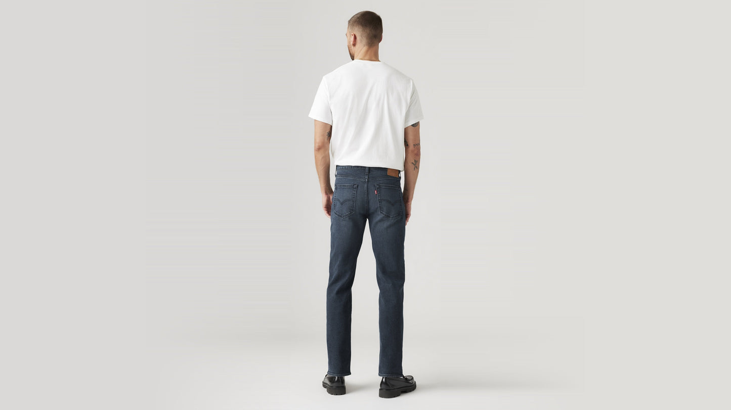Back view of a man in dark wash Levi’s 514 jeans & a white tee, hands by his sides