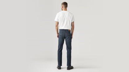 Back view of a man in dark wash Levi’s 514 jeans & a white tee, hands by his sides