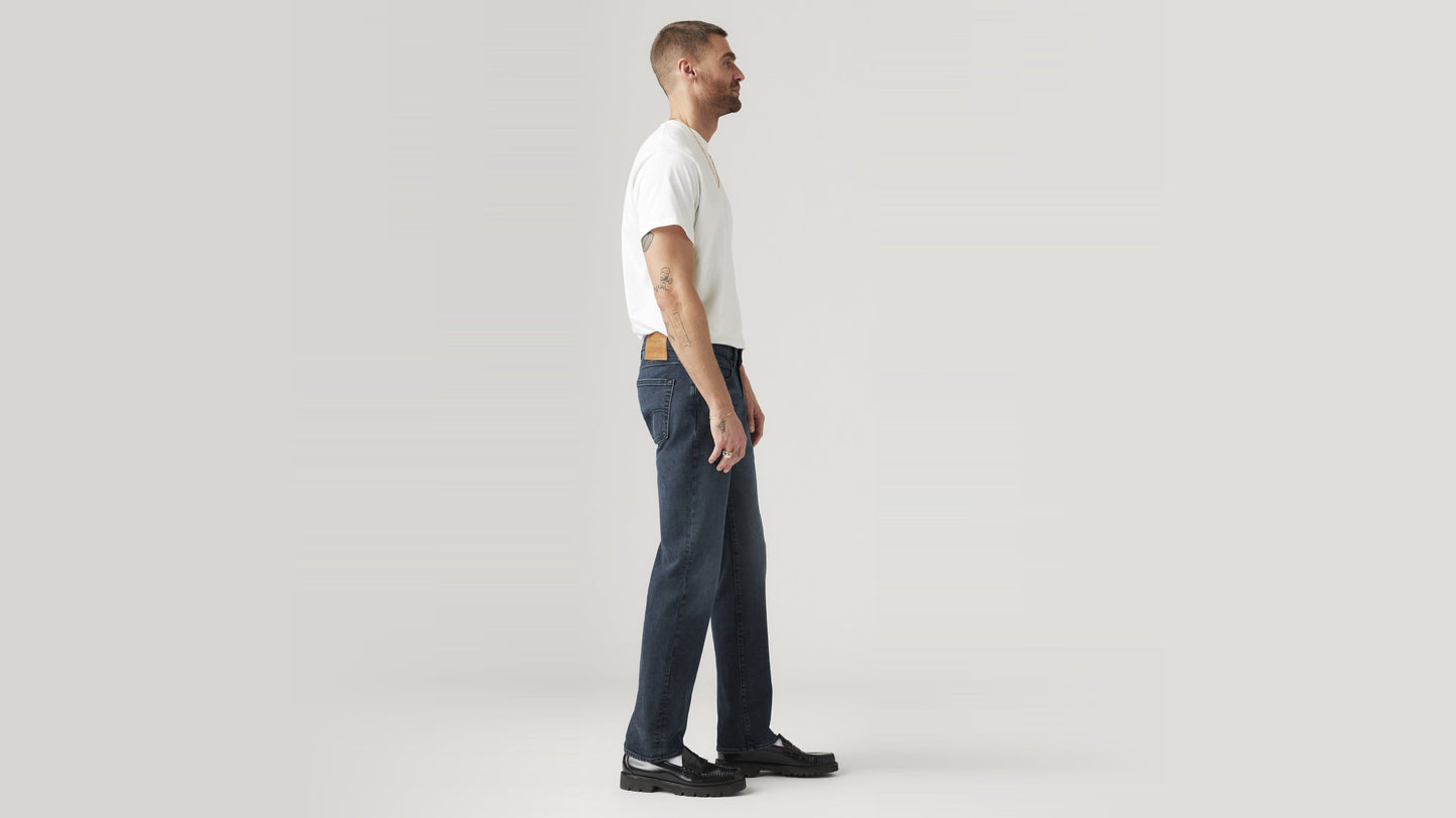 Side view of a man in dark wash straight-leg Levi’s jeans and a white tee