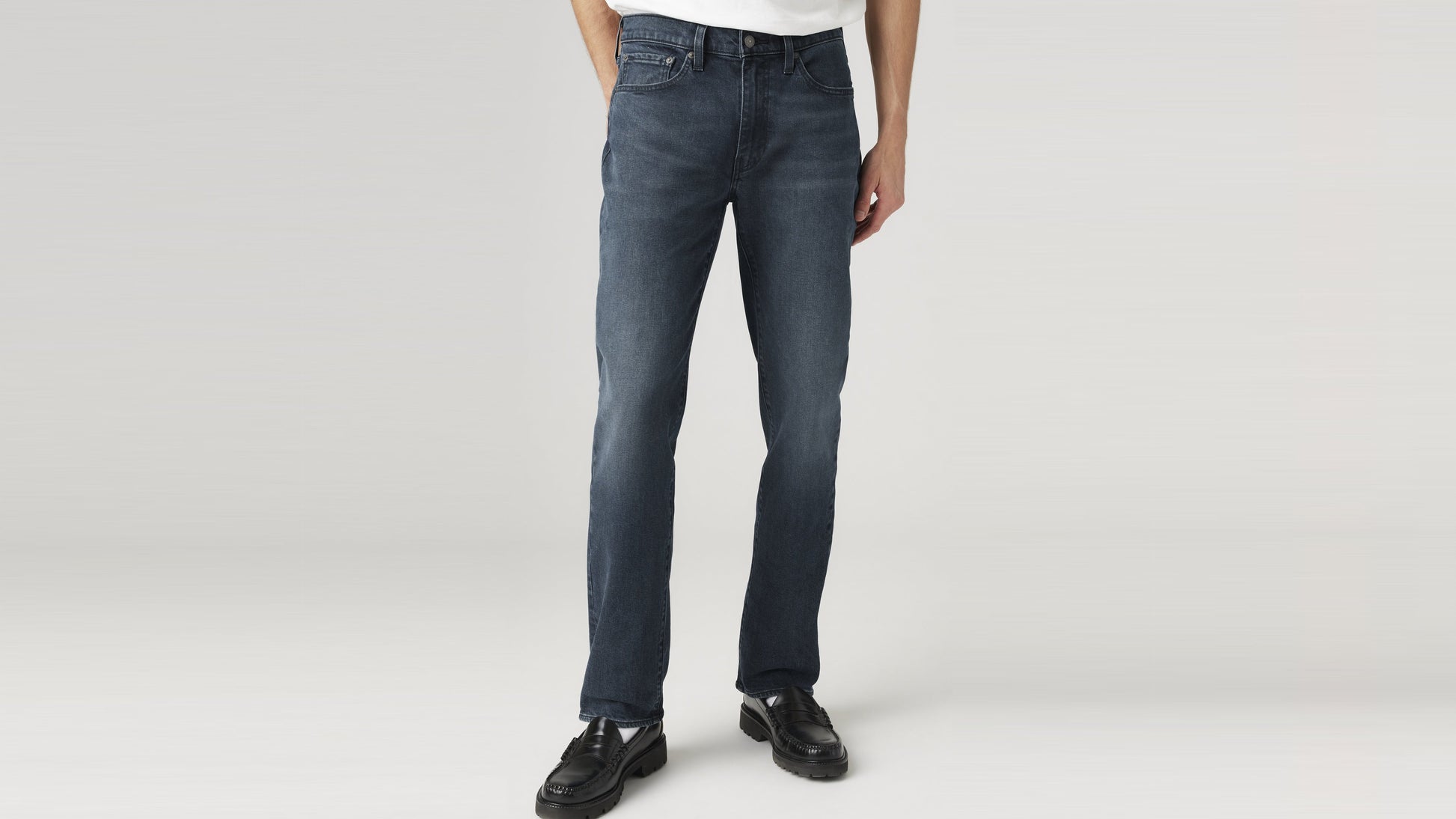Close-up front view of dark blue Levi’s 514 straight-fit jeans paired with black loafers