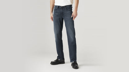 Side-front angle of dark indigo Levi’s straight-fit jeans, styled with a white tee & loafers
