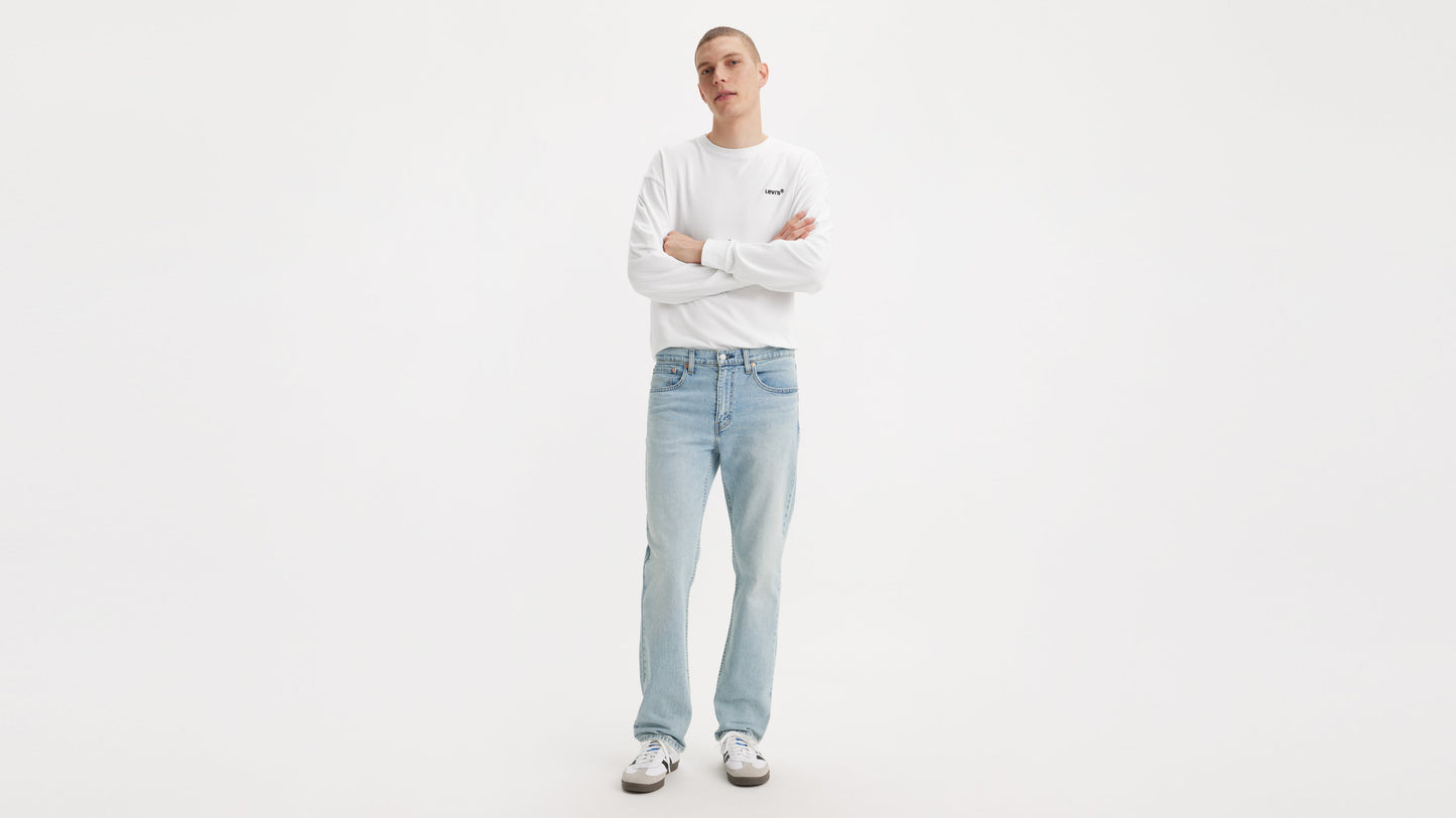 Front view of man in Levi’s Straight jeans & a white long-sleeve shirt, arms crossed