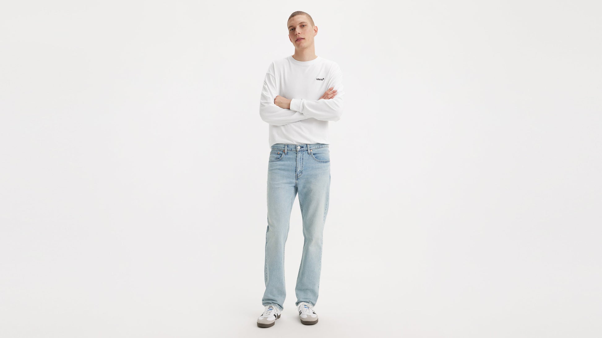 Front view of man in Levi’s Straight jeans & a white long-sleeve shirt, arms crossed