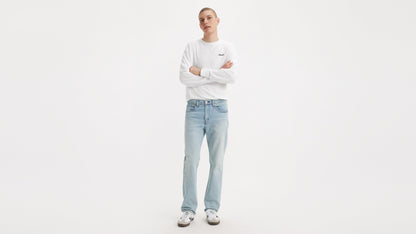 Front view of man in Levi’s Straight jeans & a white long-sleeve shirt, arms crossed
