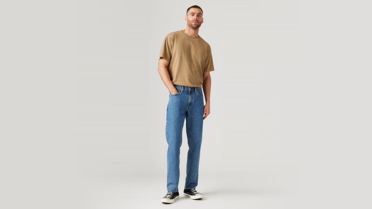 Man wearing blue Levi's 541 Athletic Taper Jeans, brown tee & sneakers, front view