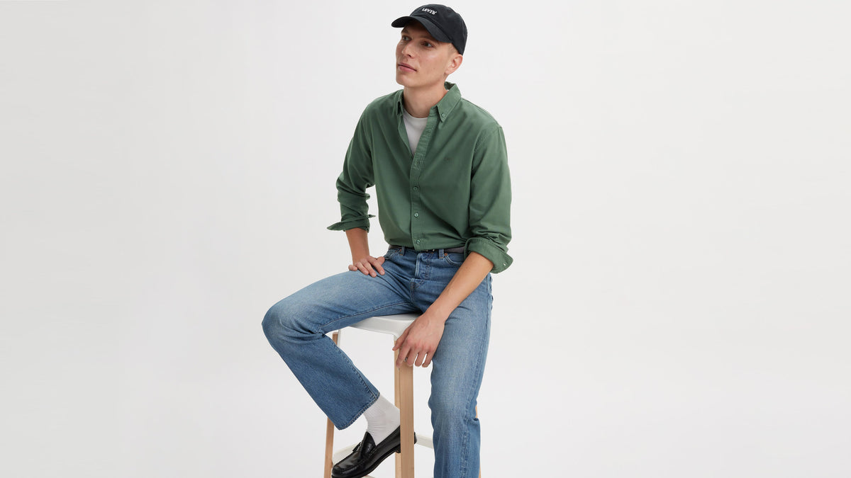 Levi’s model in green shirt and cap, seated on stool