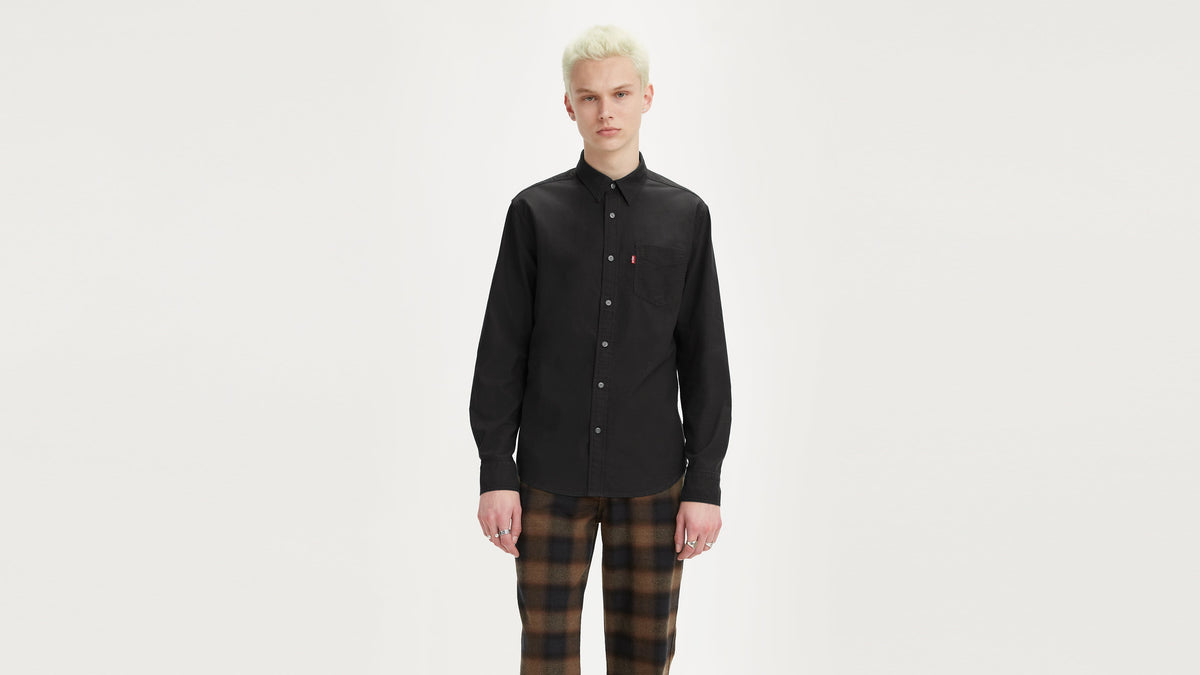 Front view of a man in a black button-up Levi's shirt paired with checkered pants