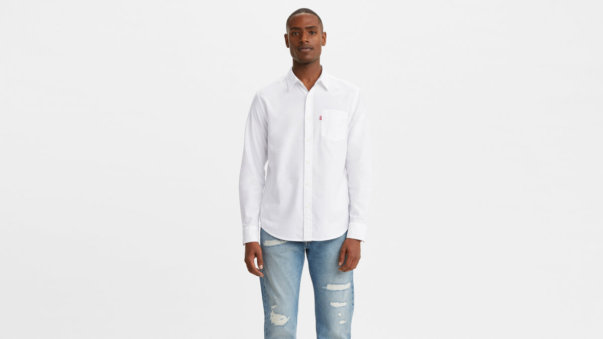 Male model in Levi's Men's white long-sleeve Classic shirt paired with ripped blue jeans