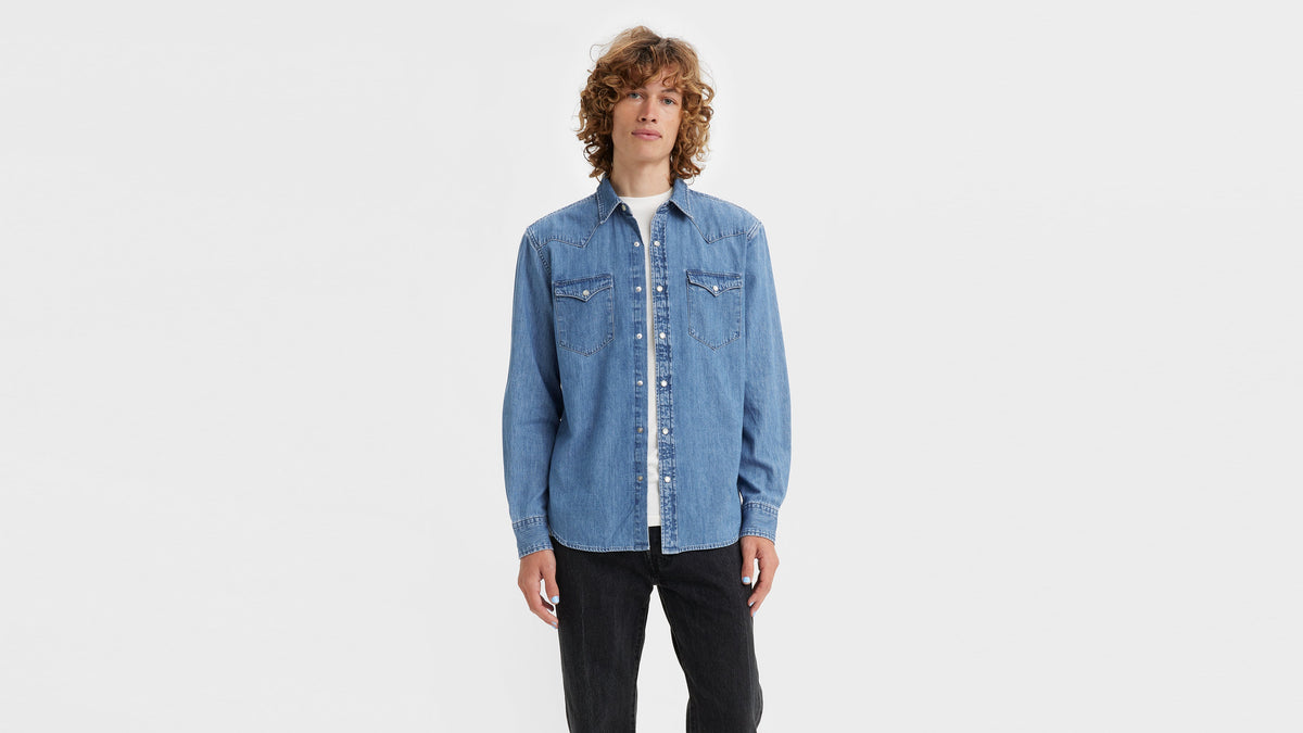 Model with curly hair wearing a denim Levi's Men's Classic denim shirt & black pants