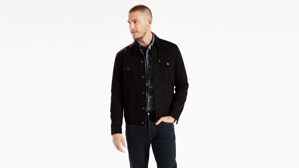 Front view of a man wearing a black Levi's Trucker jacket & dark blue jeans