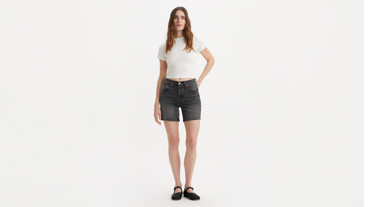 Model in black Levi's 501 Mid-Thigh Shorts with white cropped top