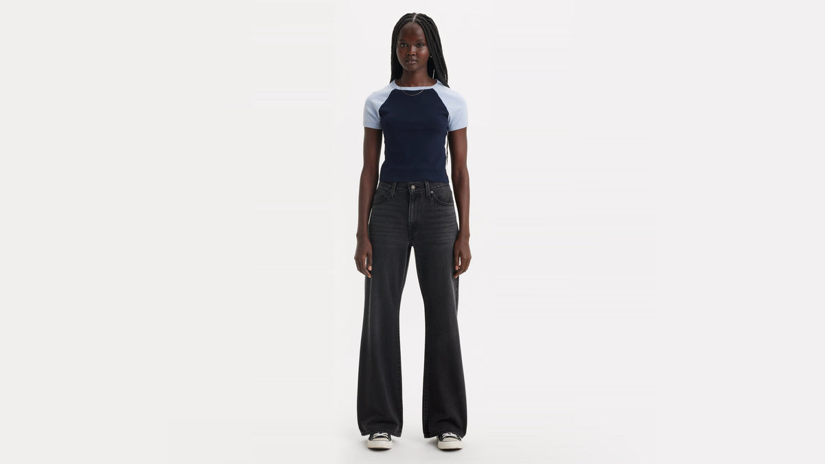 Front view of a woman in a navy shirt, black Baggy jeans, & sneakers