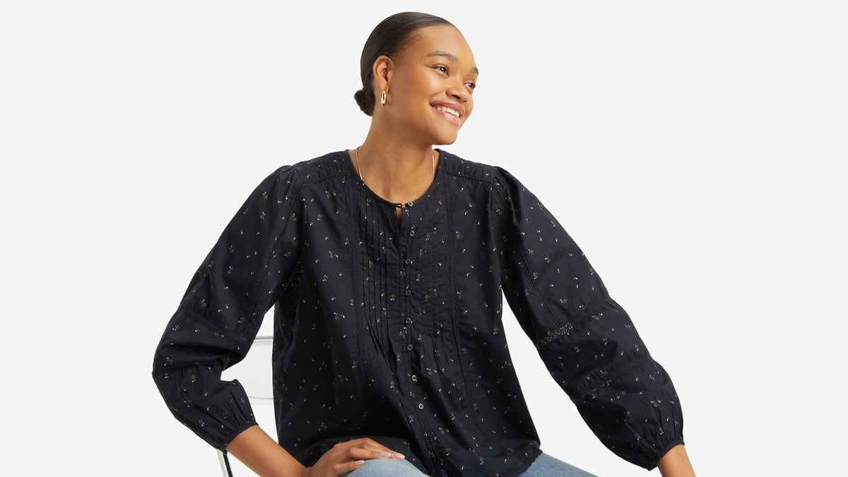 Woman in navy long-sleeve blouse with pintuck details