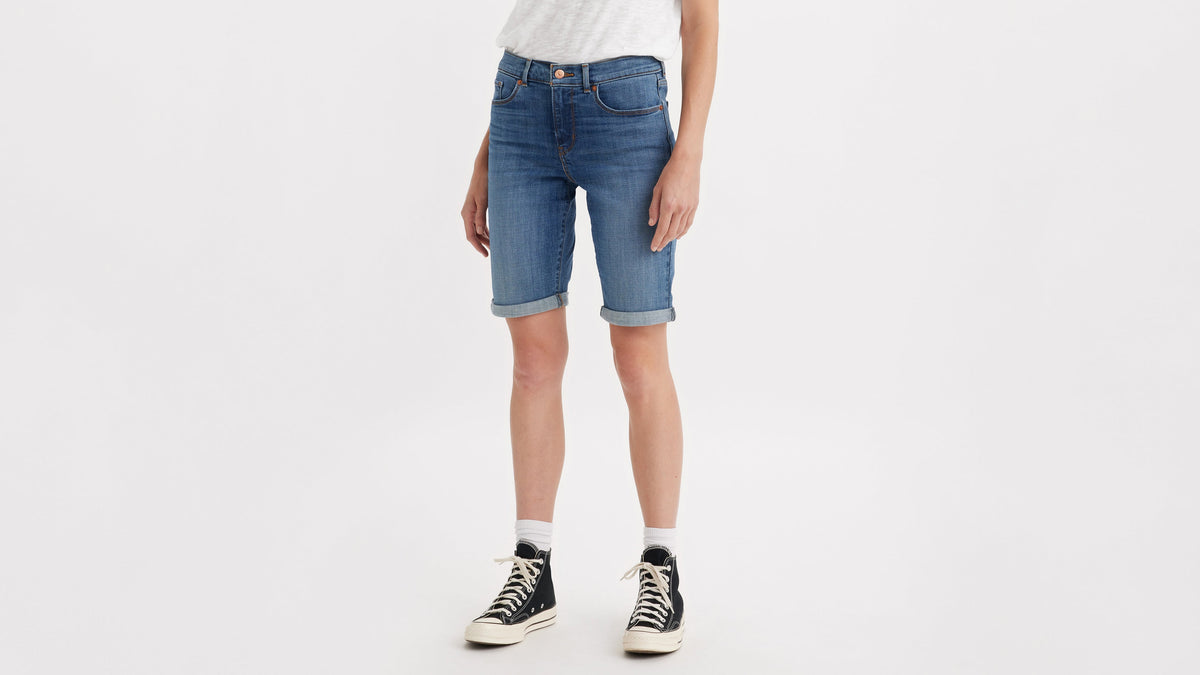 Half-body shot of a woman in Levi's classic bermuda shorts with black sneakers