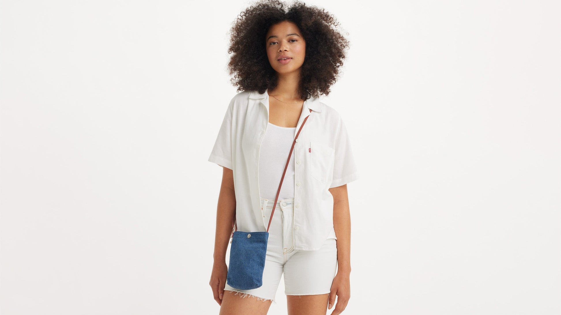 Woman in white Levi’s outfit with denim phone pouch