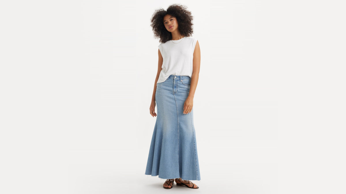 Model wears light-wash Levi’s mermaid skirt with raw hem and flared silhouette