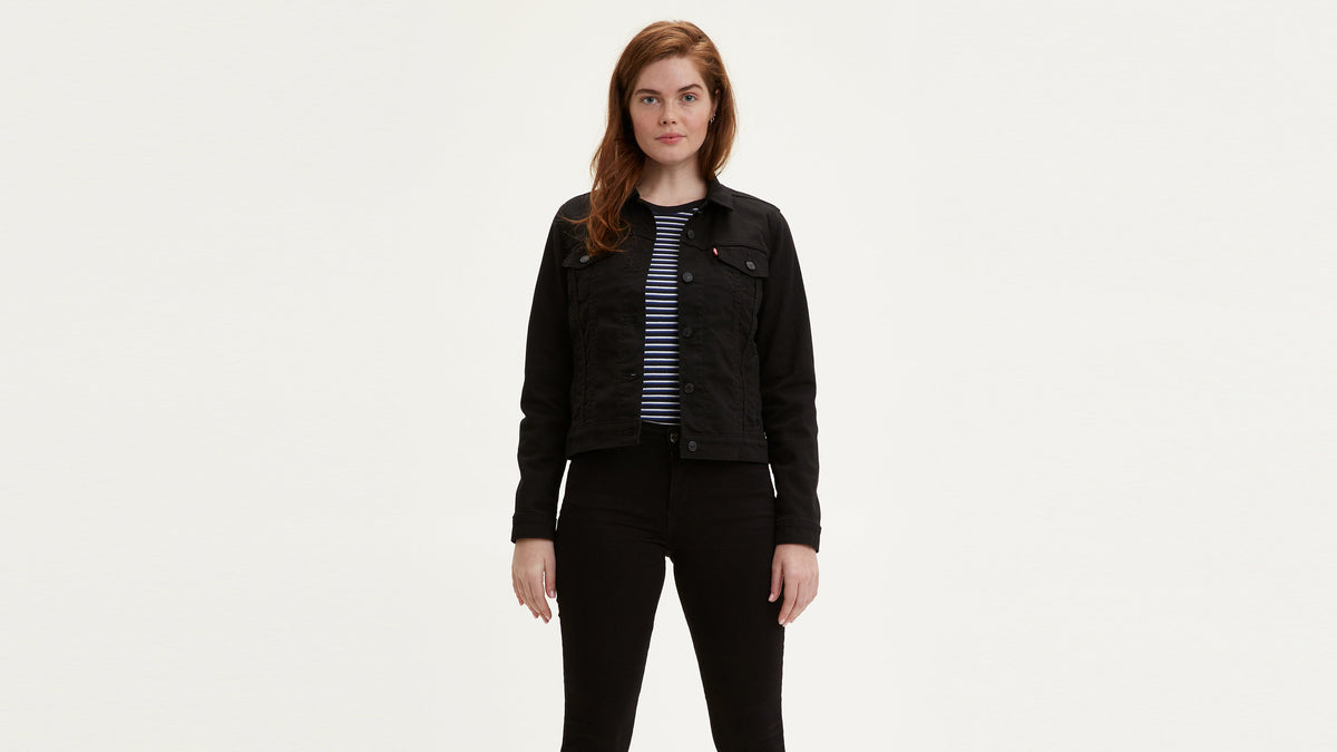 Front view of woman in layered striped tee, black trucker jacket, & black jeans