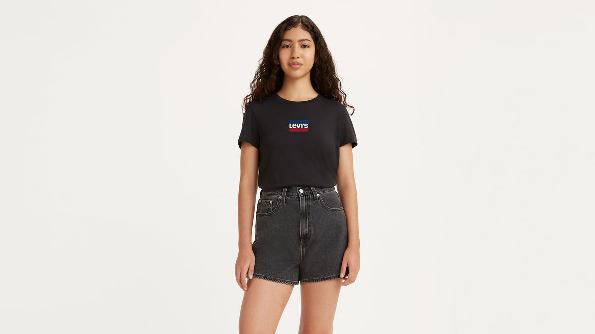 Woman wears black Levi’s perfect tee paired with black denim shorts, front view