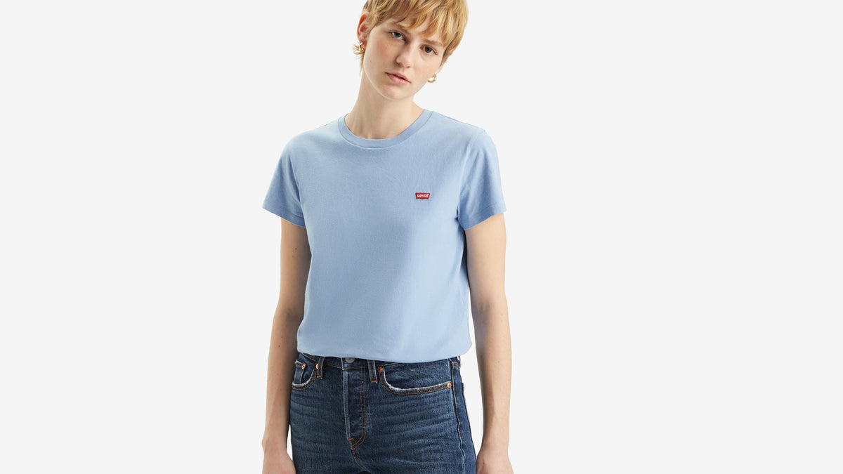 Woman wearing light blue Levi’s T-shirt and dark jeans