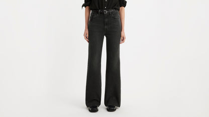 Half-body shot of a woman in black Levi's ribcage bell jeans & black shoes