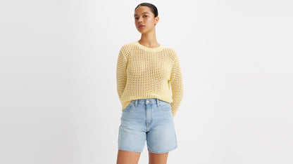 Woman in a knitted yellow top and casual denim shorts
