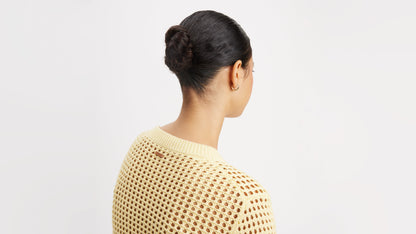 Back view of a woman wearing a cream crochet sweater