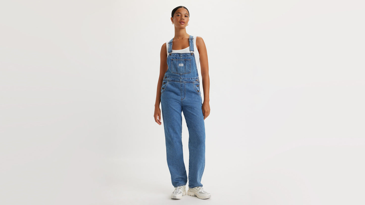 Woman in Levi’s denim overalls with hands at sides