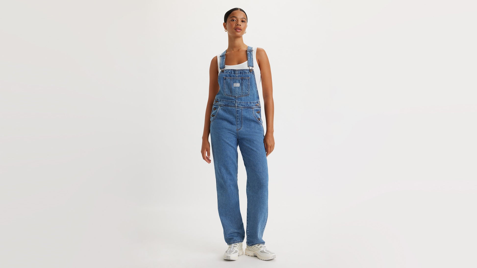 Woman in Levi’s denim overalls with hands at sides