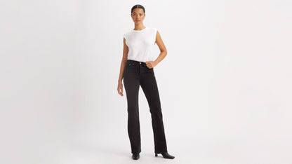 Woman in white top, black Levi's Wedgie Jeans, & black boots, front view